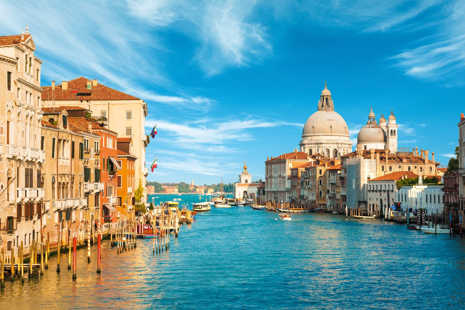 Venice waterfront and domed churches under a bright blue sky